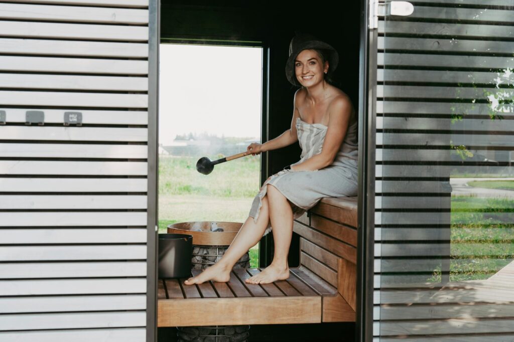 A woman in a sauna, wrapped in a towel, enjoying a relaxing steam session with a