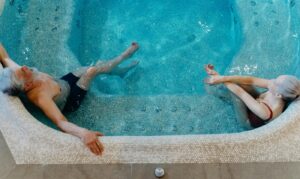 Elderly couple enjoying leisure time in a swimming pool. Overhead view.
