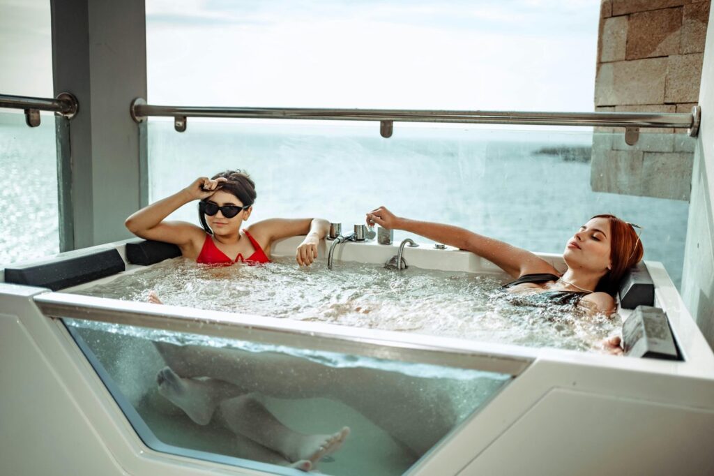 Two women enjoying a relaxing jacuzzi with a stunning ocean view.