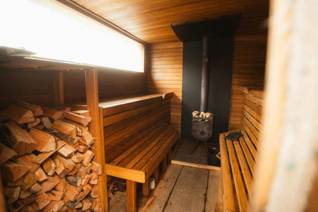 Warm wooden sauna interior with benches and fireplace, offering a relaxing and i